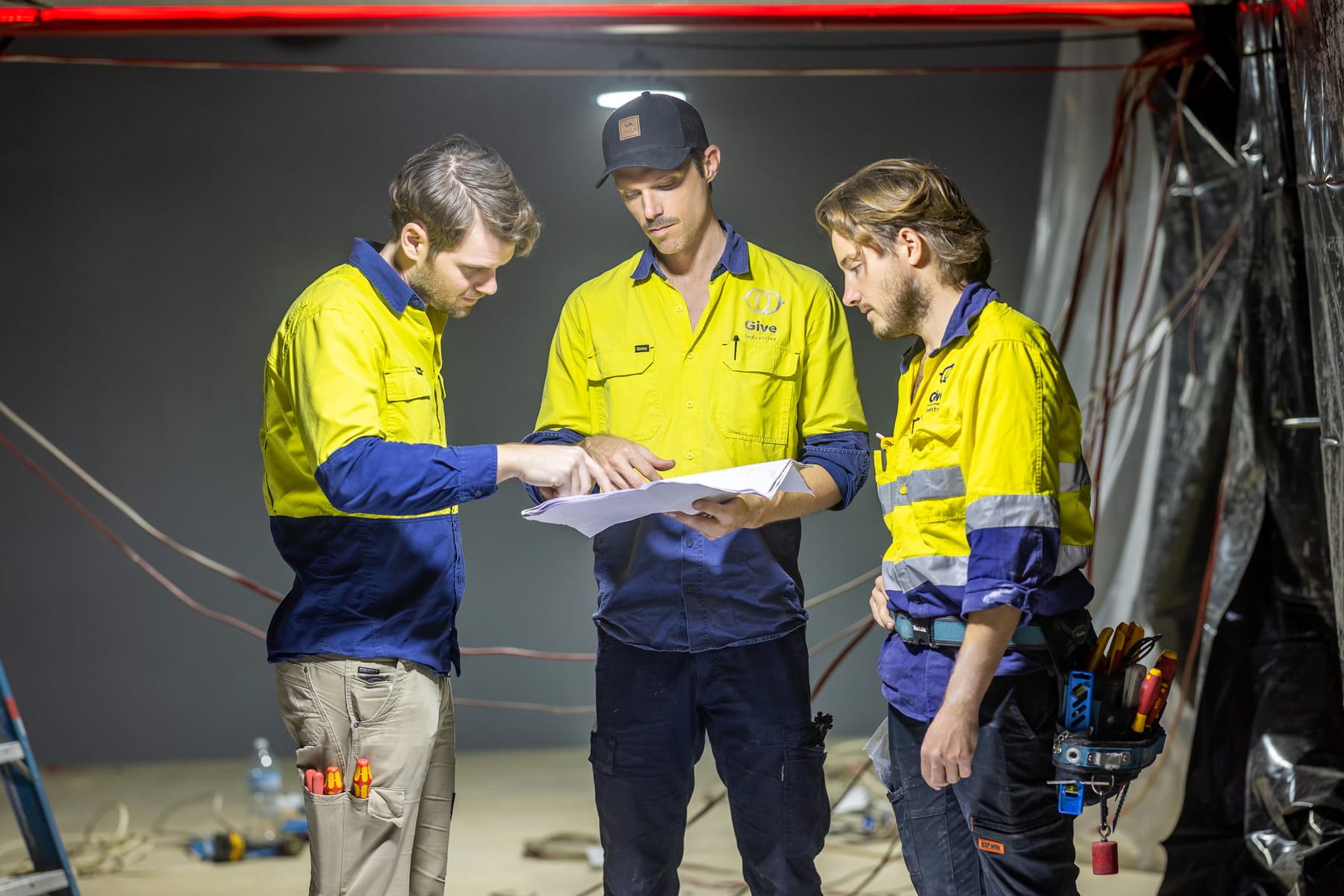 Give Industries electricians reviewing plans on site